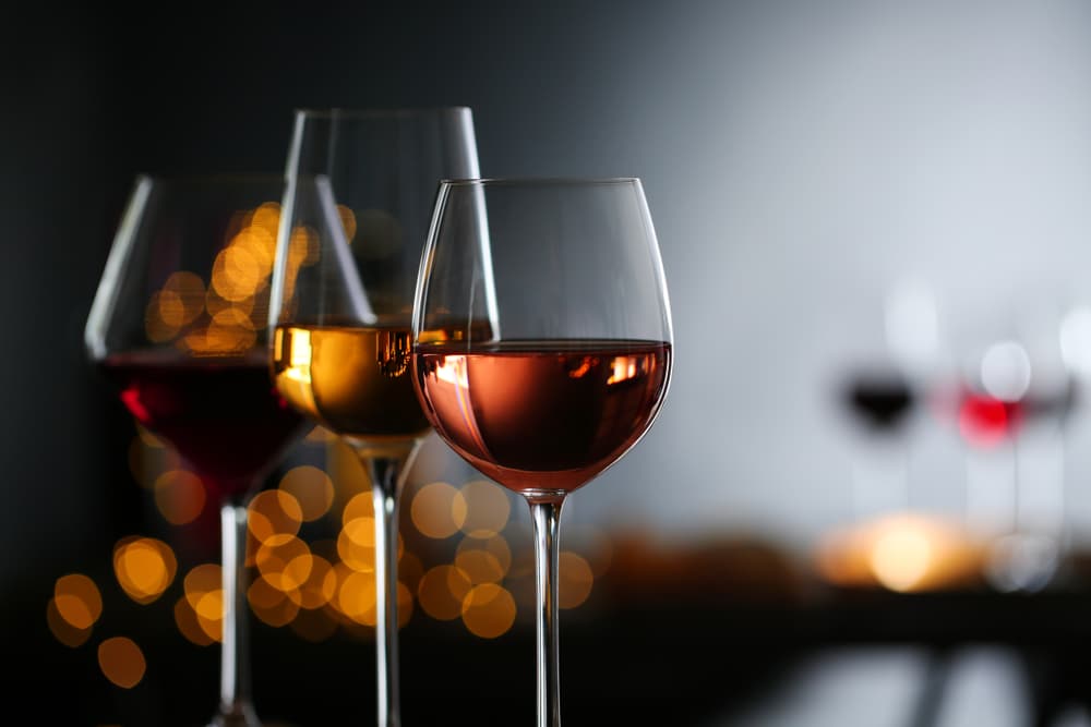 Finger Lakes Wineries, picture of a glass of rose, white, and red wines with sparkling lights