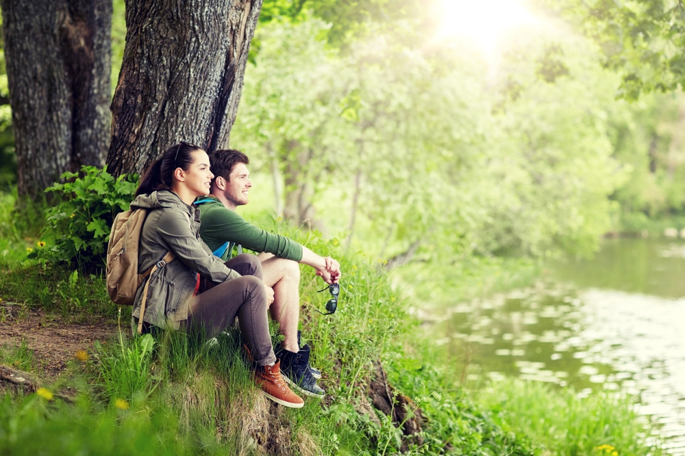 Robert Treman State Park, photo of a couple sitting during a hike in the park looking at the water