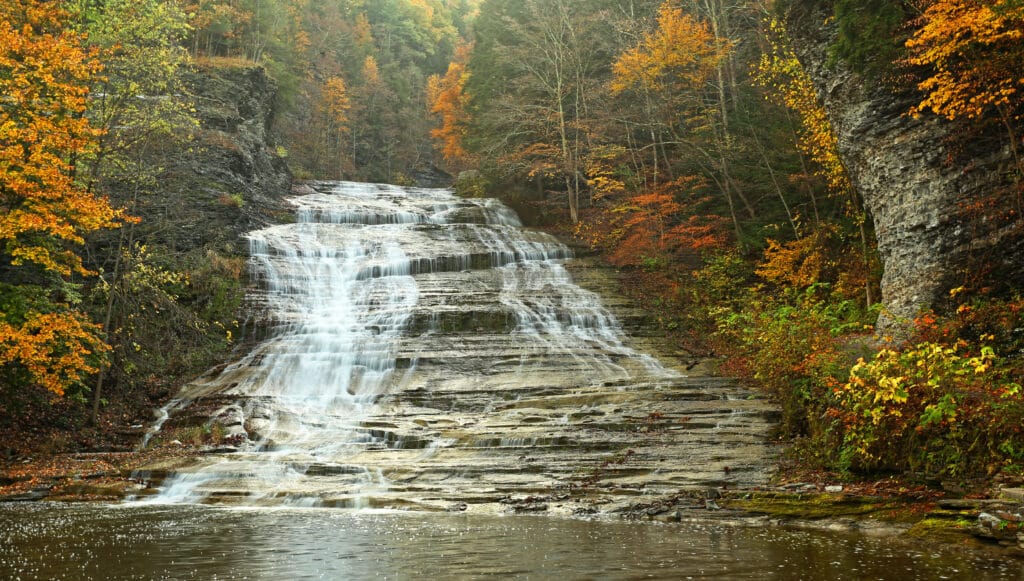 Hiking at Buttermilk Falls State Park 1 Buttermilk Falls State Park in autumn with vibrant fall foliage.