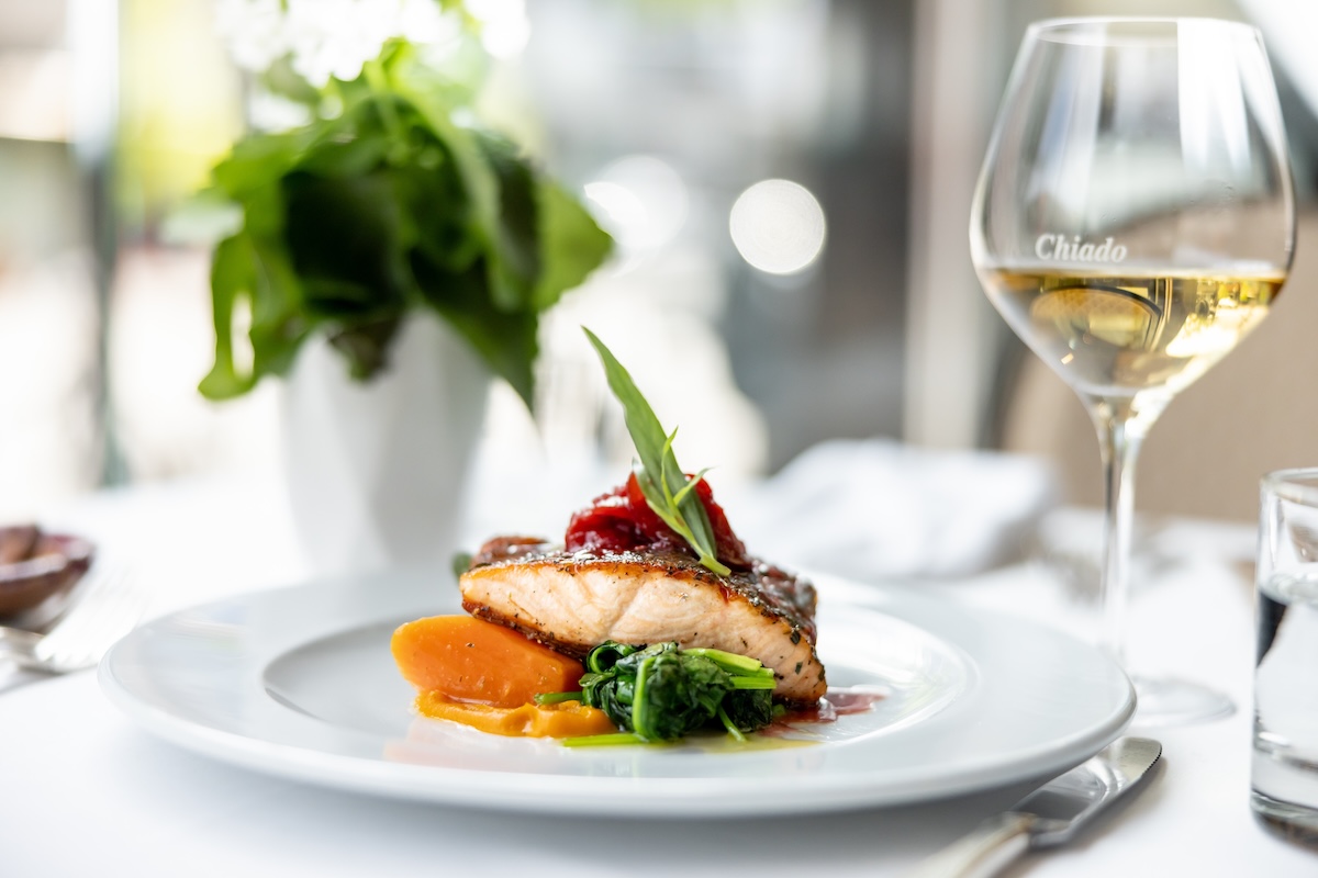 Delicious gourmet meal entree at fancy restaurant on white linen table clth in the summer
